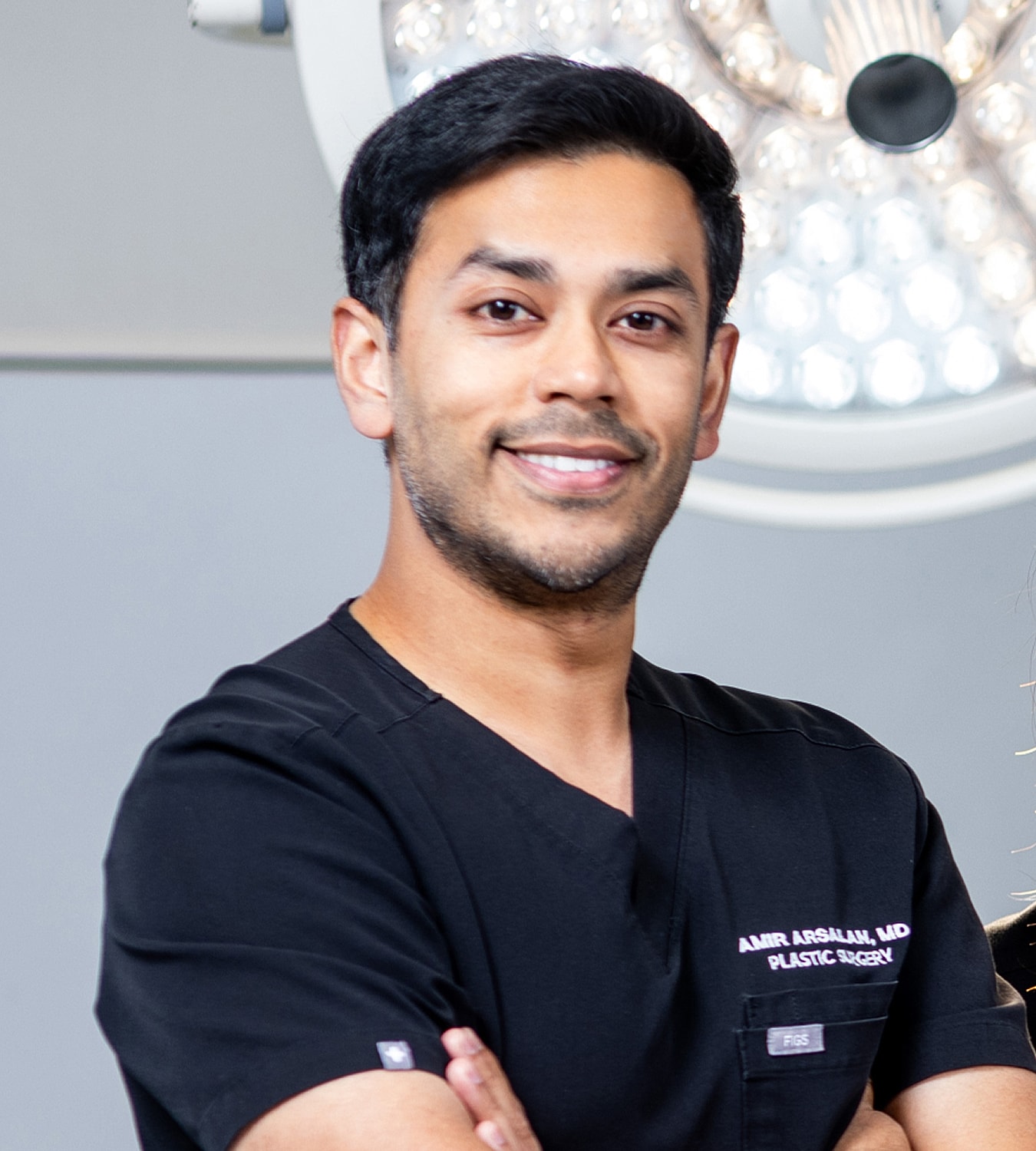 Plastic surgeon smiling in professional attire.