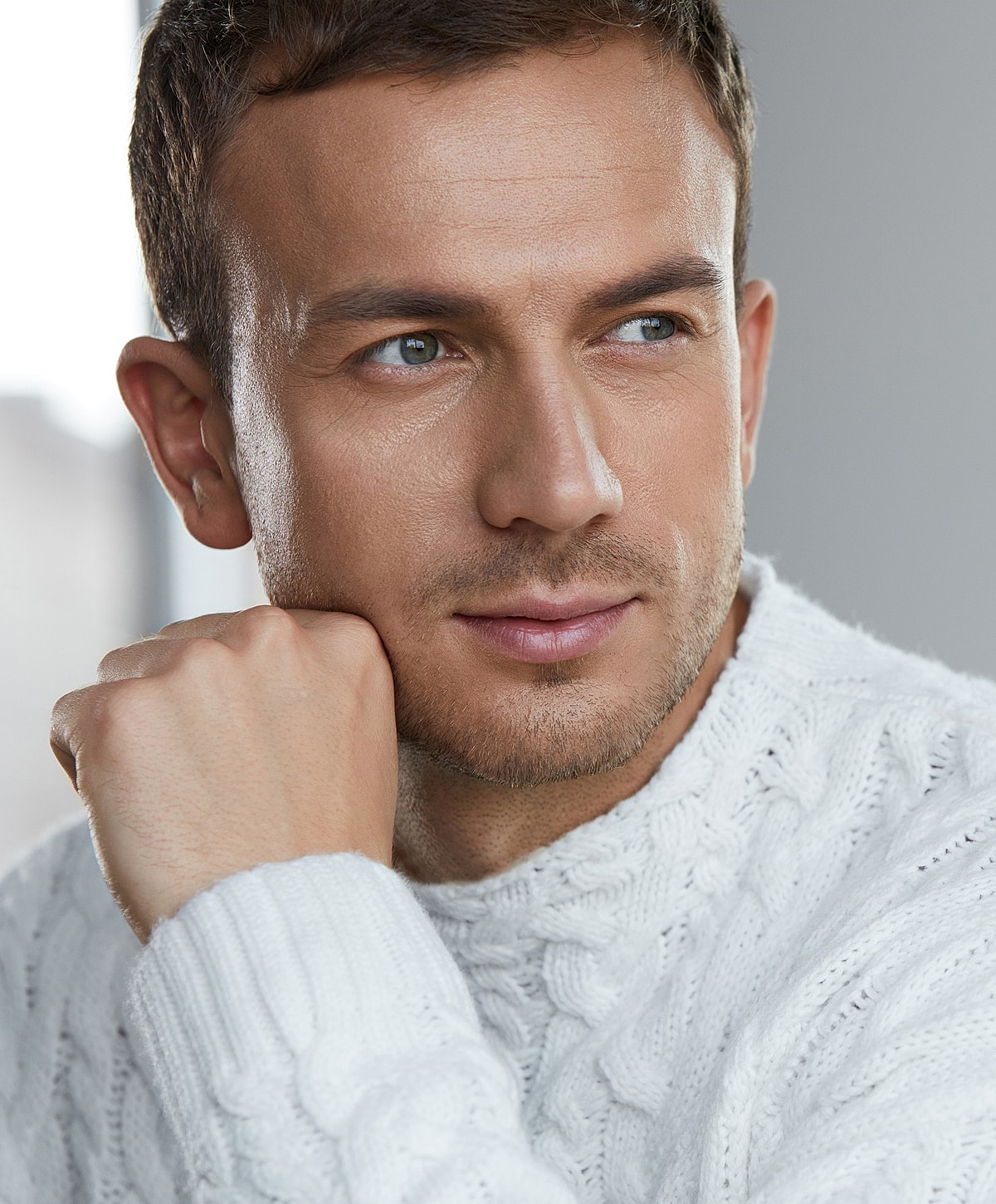 Thoughtful man in a cozy white sweater.