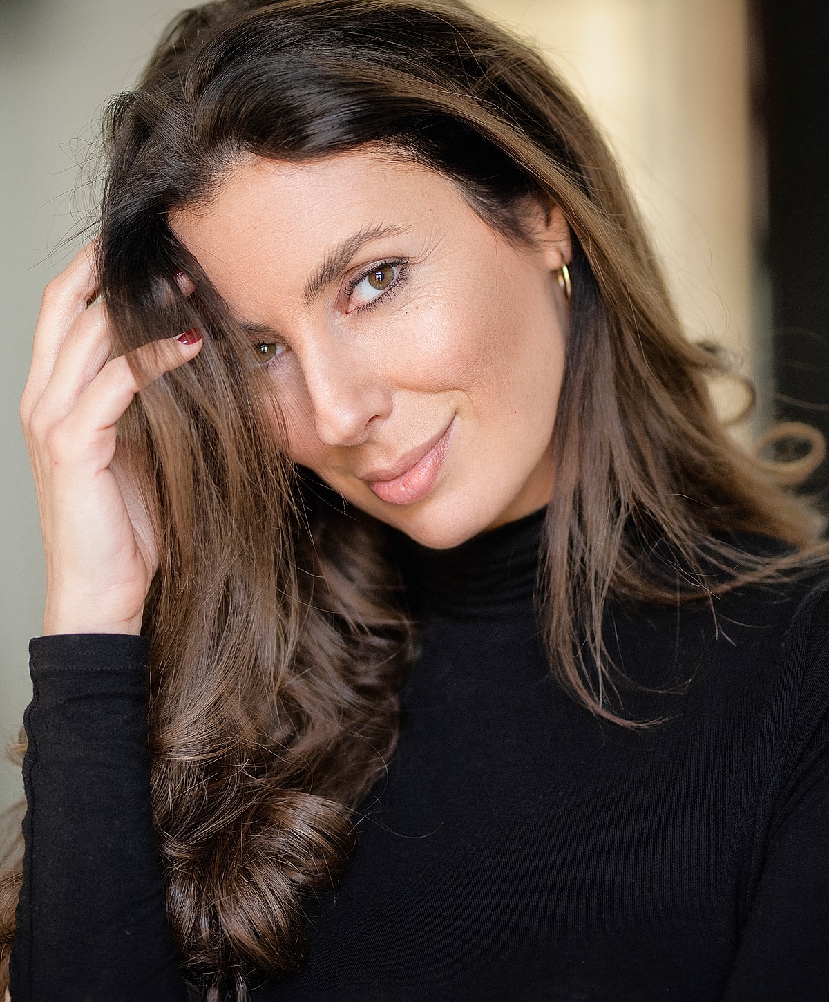 Smiling woman with long hair in black top.