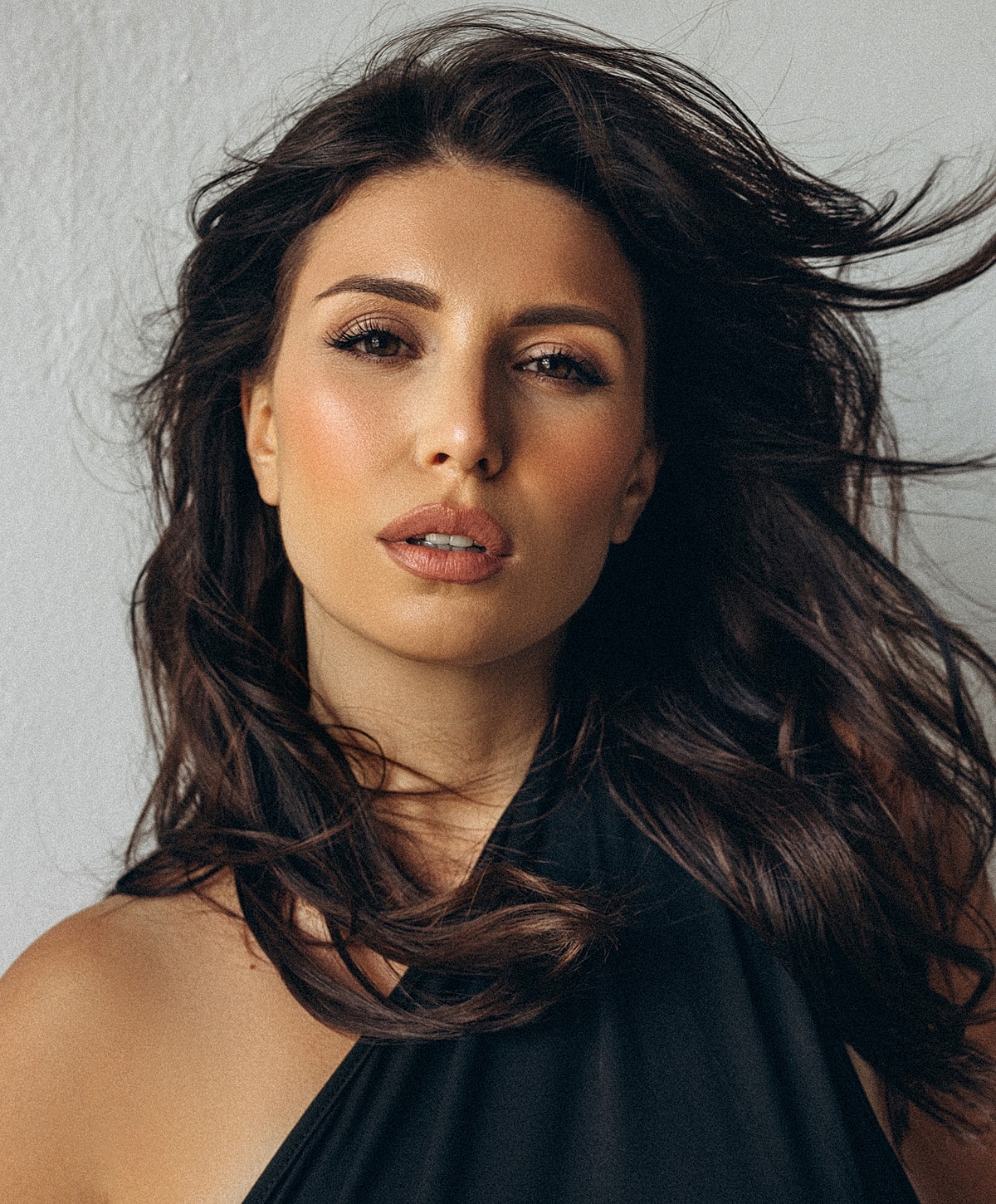 Woman with flowing hair against a neutral background.
