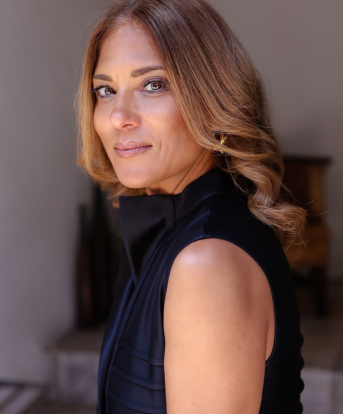 Woman with styled hair in elegant outfit.