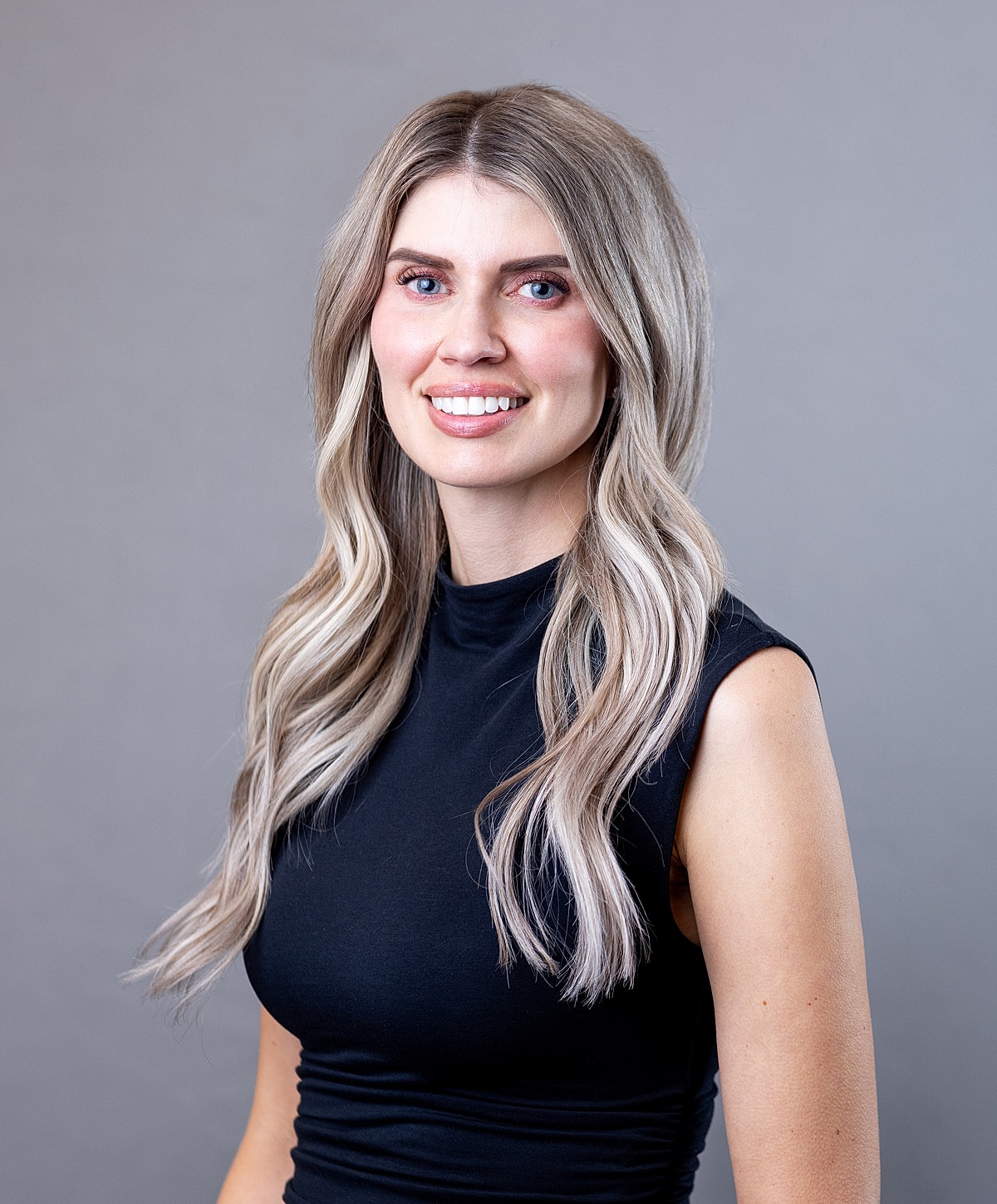 Smiling woman with long hair and black top.