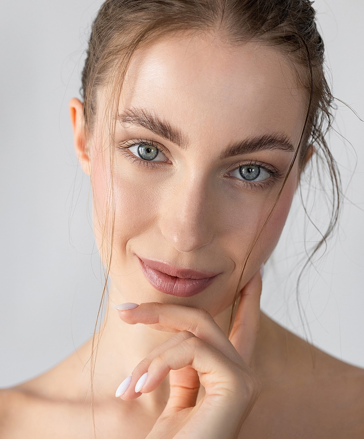 Woman with natural makeup and thoughtful expression.