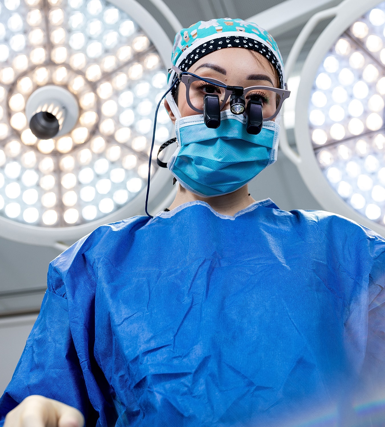 Surgeon preparing for procedure under operating lights.