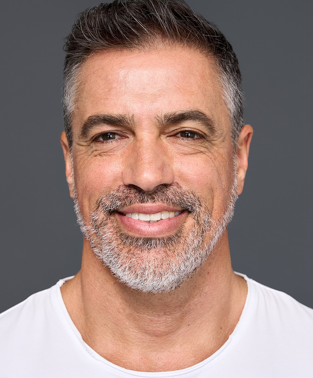 Smiling man with short gray hair and beard.