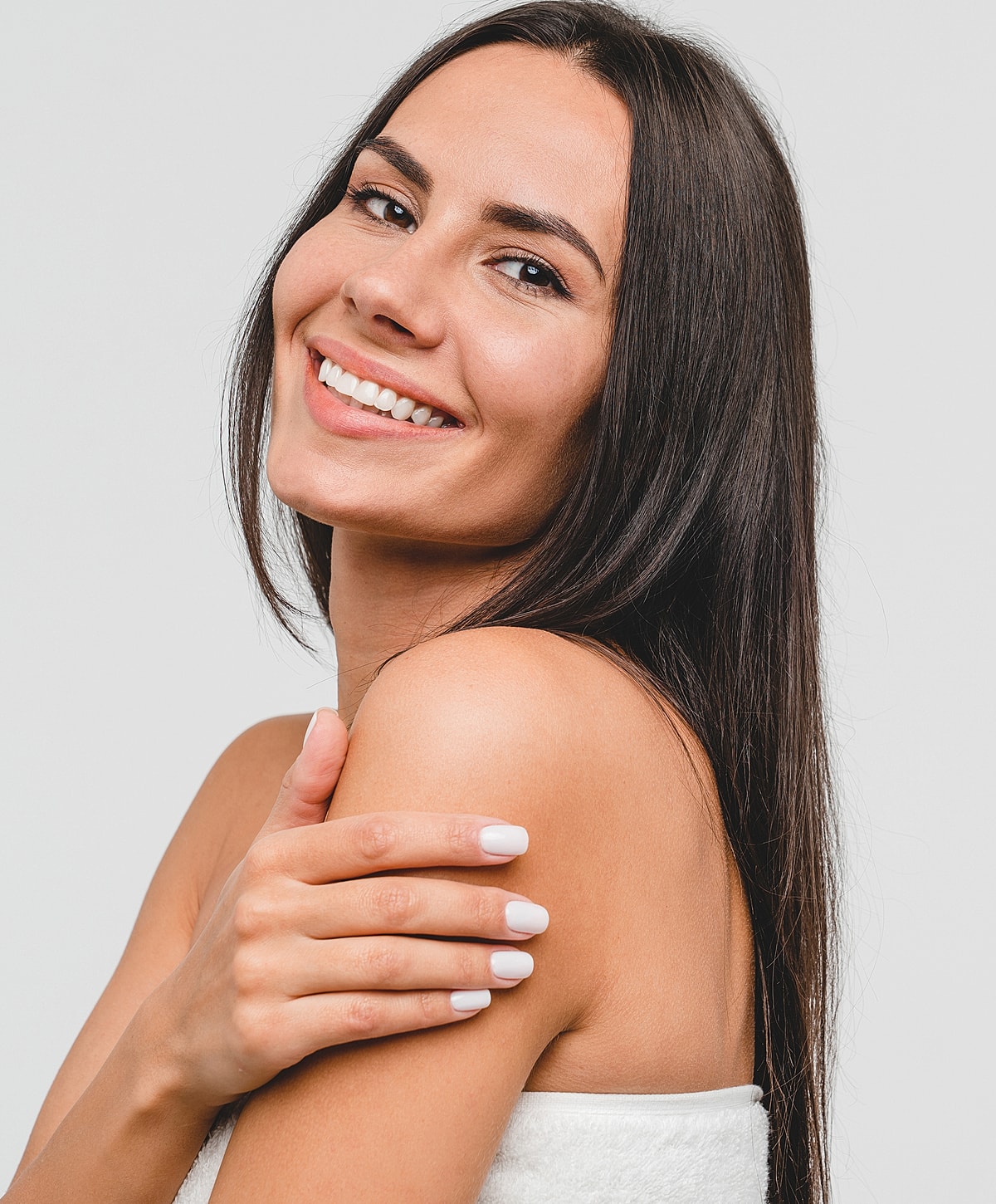 Smiling woman with long hair and natural nails.