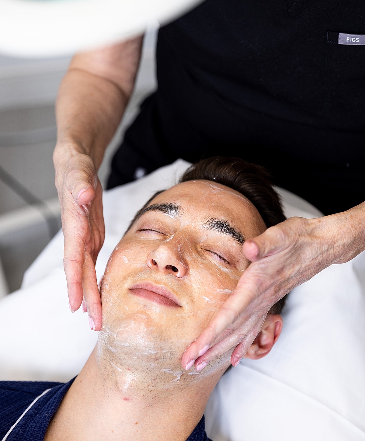 Man receiving a facial treatment in a spa.