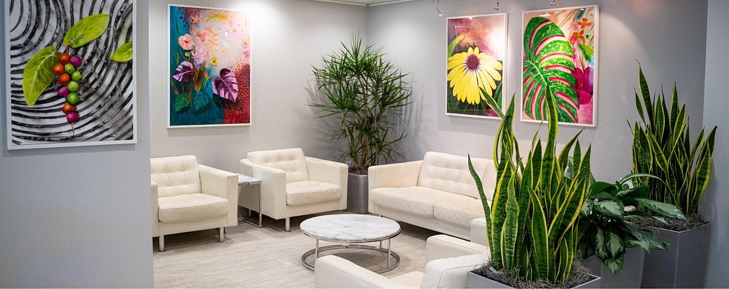 Modern lounge with vibrant artwork and plants.