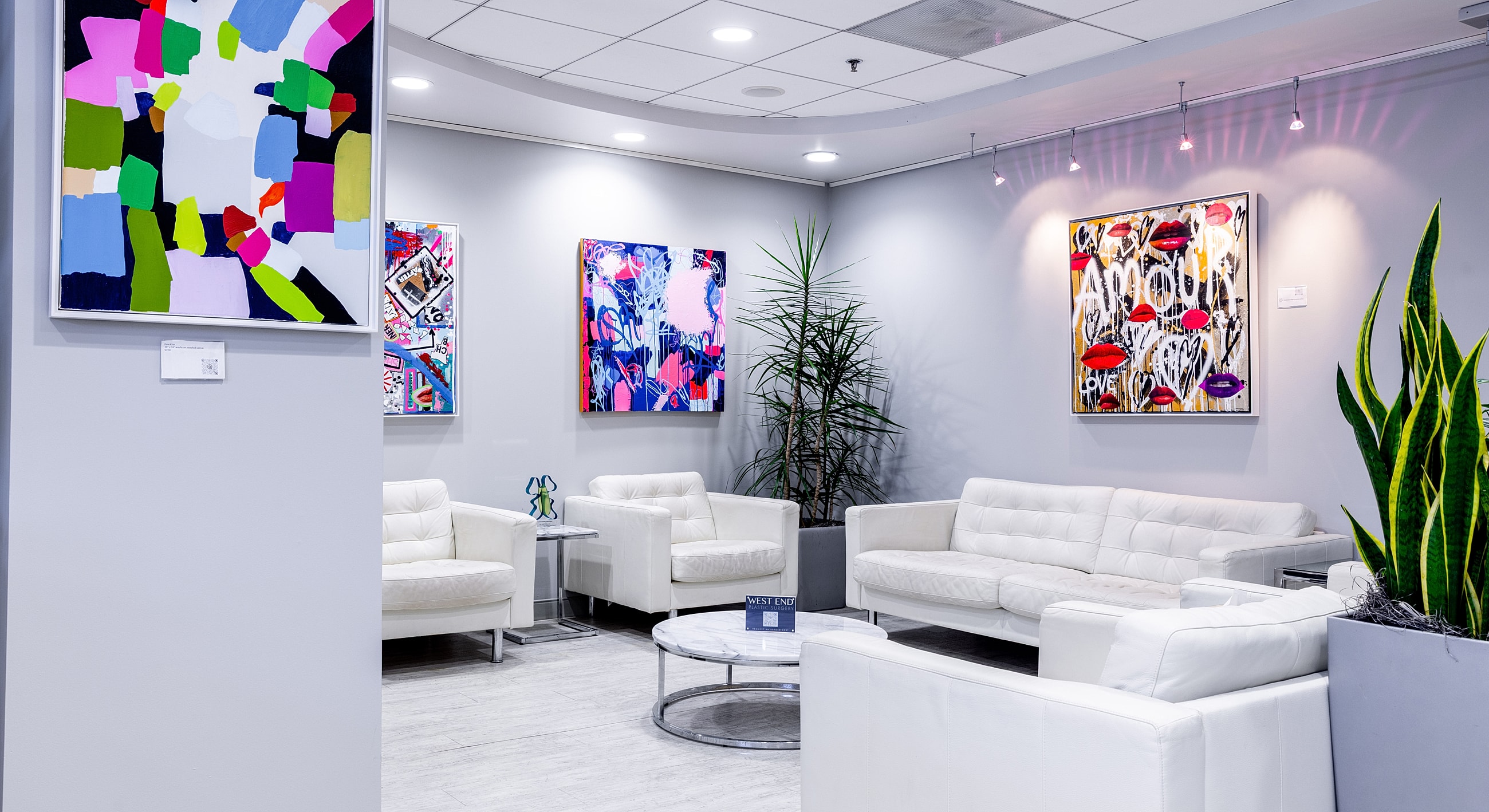 Modern lounge with colorful artwork and plants.