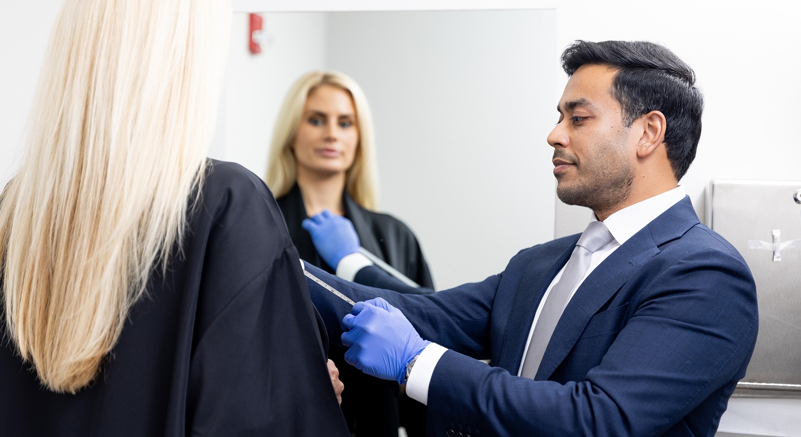 Measuring a client's arm for fitting adjustments.