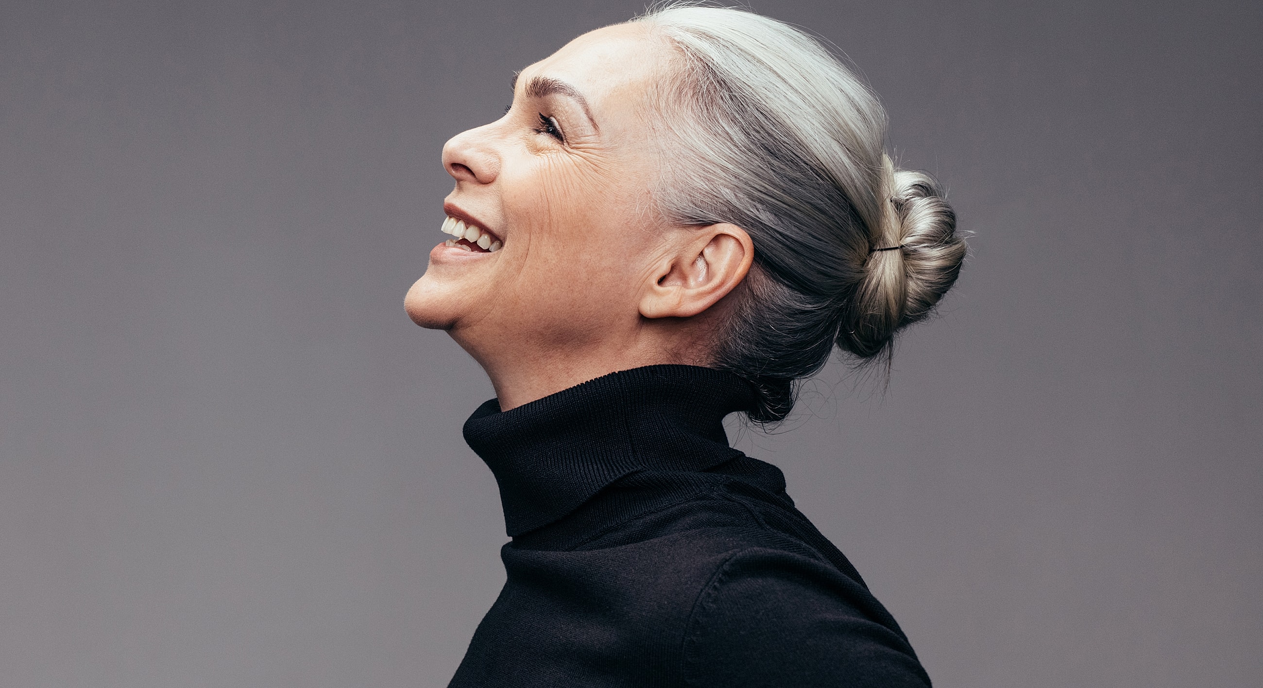 Smiling woman with gray hair in profile view