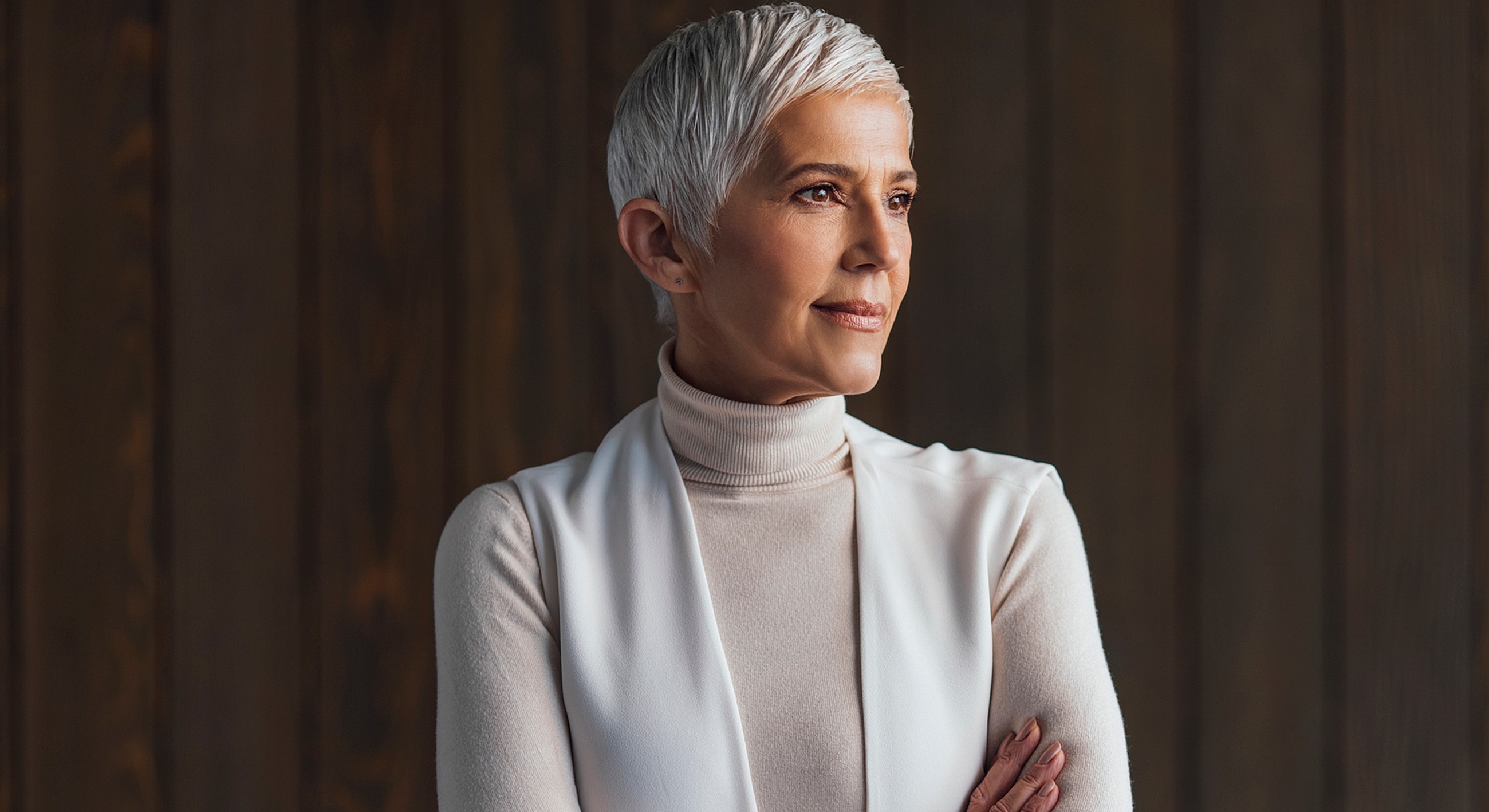 Confident woman with short silver hair, thoughtful expression.