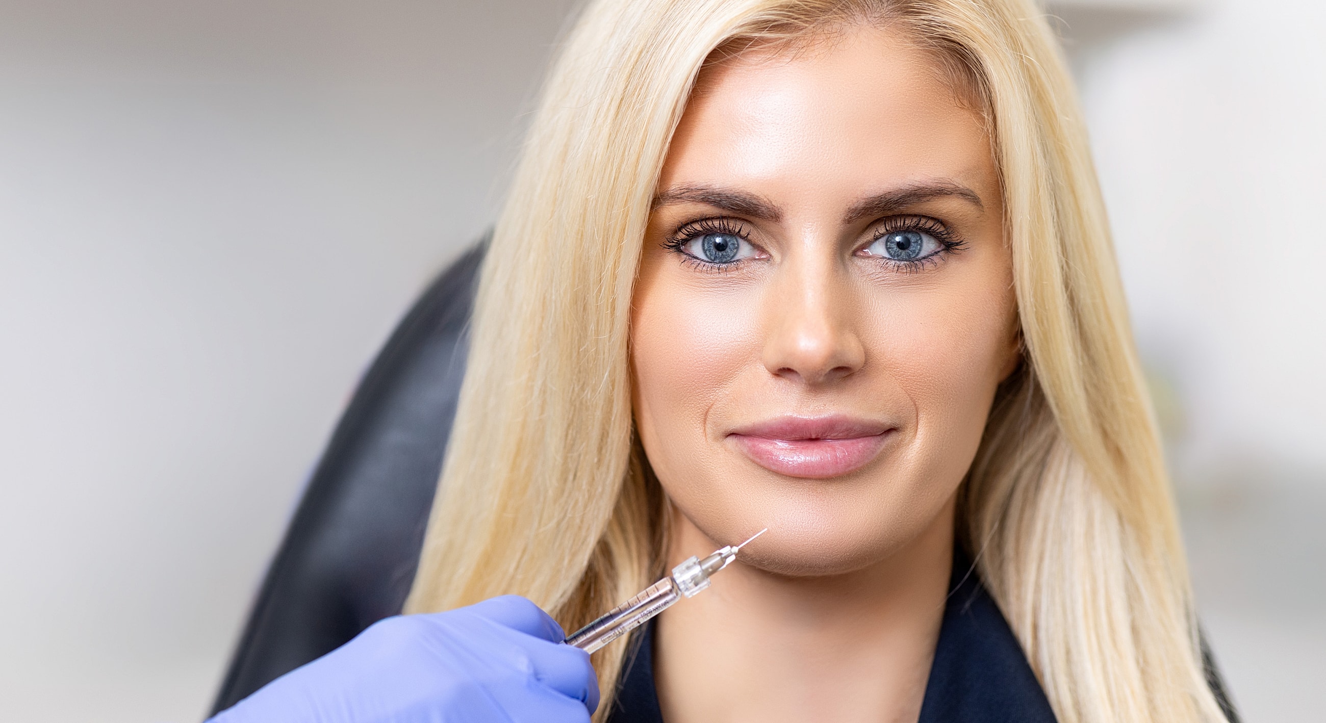 Woman receiving facial treatment with injection.