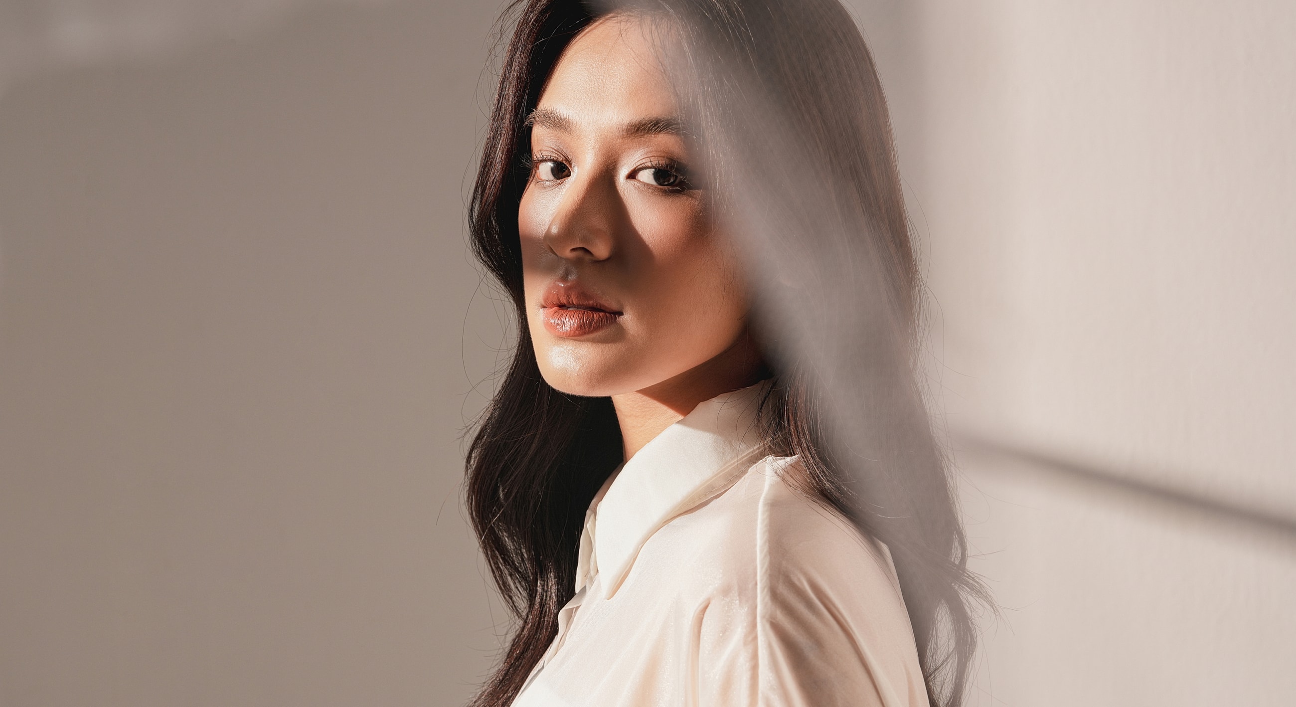 Woman with long hair in soft lighting.